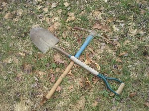Shovel and Pickaxe crossed on the ground. Tools for gardening in April in New England.